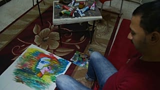 تعرف على رضا فضل.. فنان يرسم بفمه وقدميه