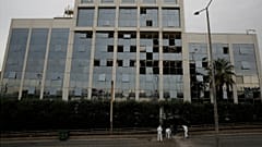 Investigadores forenses recolhem vestígios diante do edifício da Skai TV