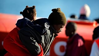 A migrant woman and her child safely disembark in Malaga.