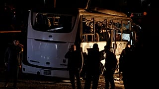 Riot police secure a scene of a bus blast in Giza