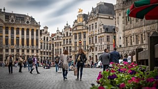 People walk across the Grand Place Square in Brussels, Belgium.