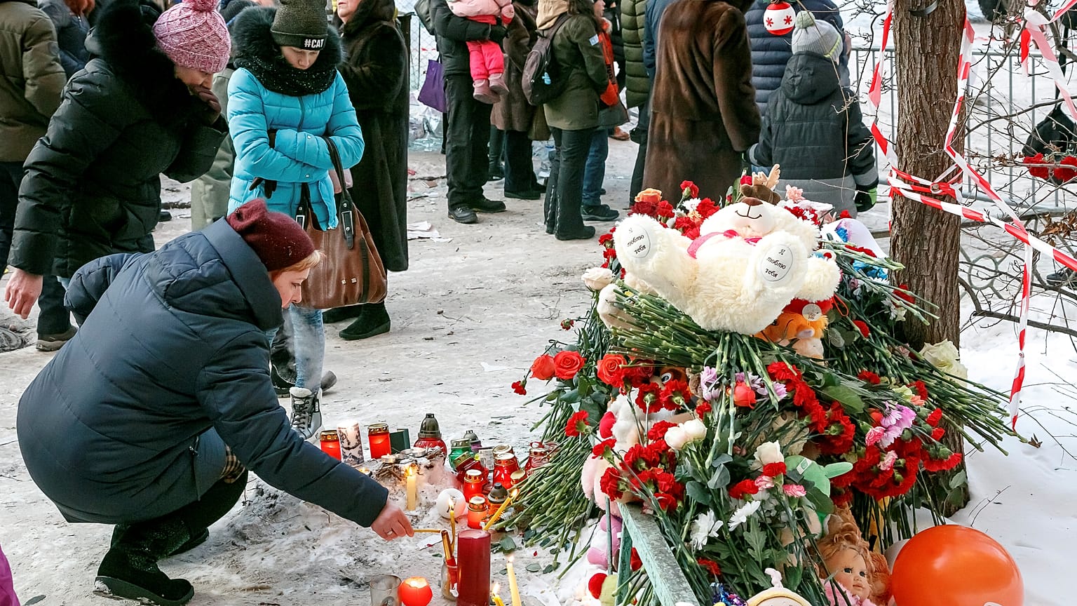 People leave tributes near the site of the partially collapsed building