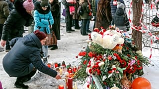 People leave tributes near the site of the partially collapsed building