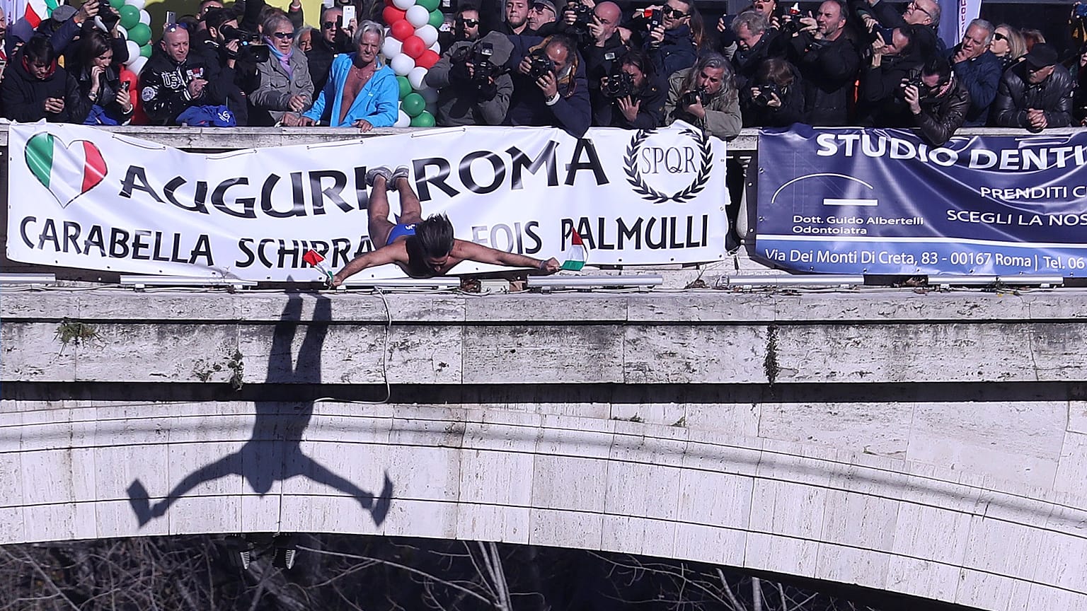 Walter Schirra, dives into the Tiber River from the Cavour bridge in Rome