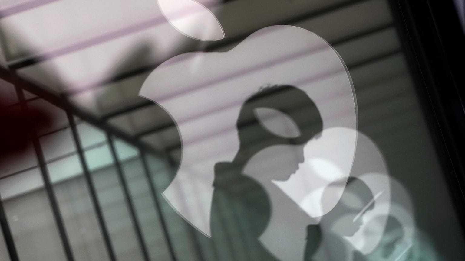 Apple-Logo-Reflektionen und Silhouette eines Menschen