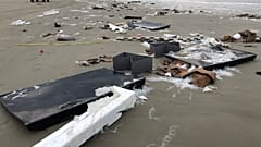 Flat-screen TVs and debris lie washed up on beach in Terschelling