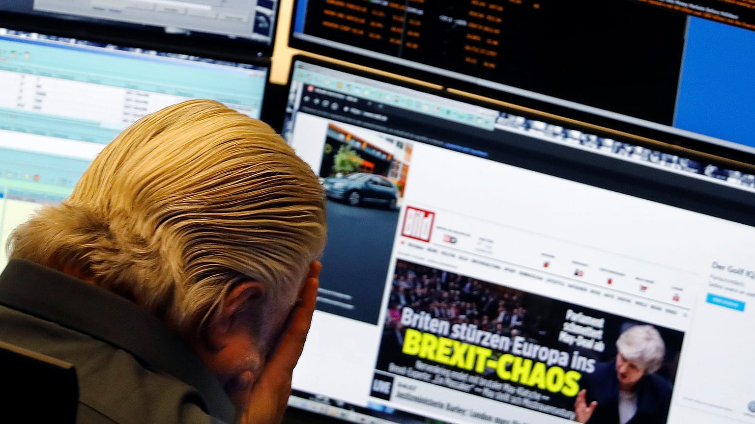 A share trader reacts as he reads the headline "Brexit chaos"