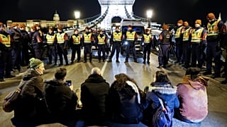  Rendőrök állnak a Lánchídon ülő demonstrálókkal szemben Budapesten