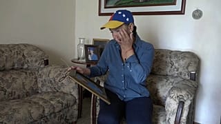 Nelly Pompa cries as she looks at a picture of her son Miguel