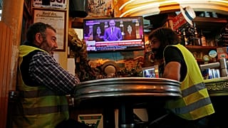 Christophe Chalencon (left) watching a televised speech by France's PM