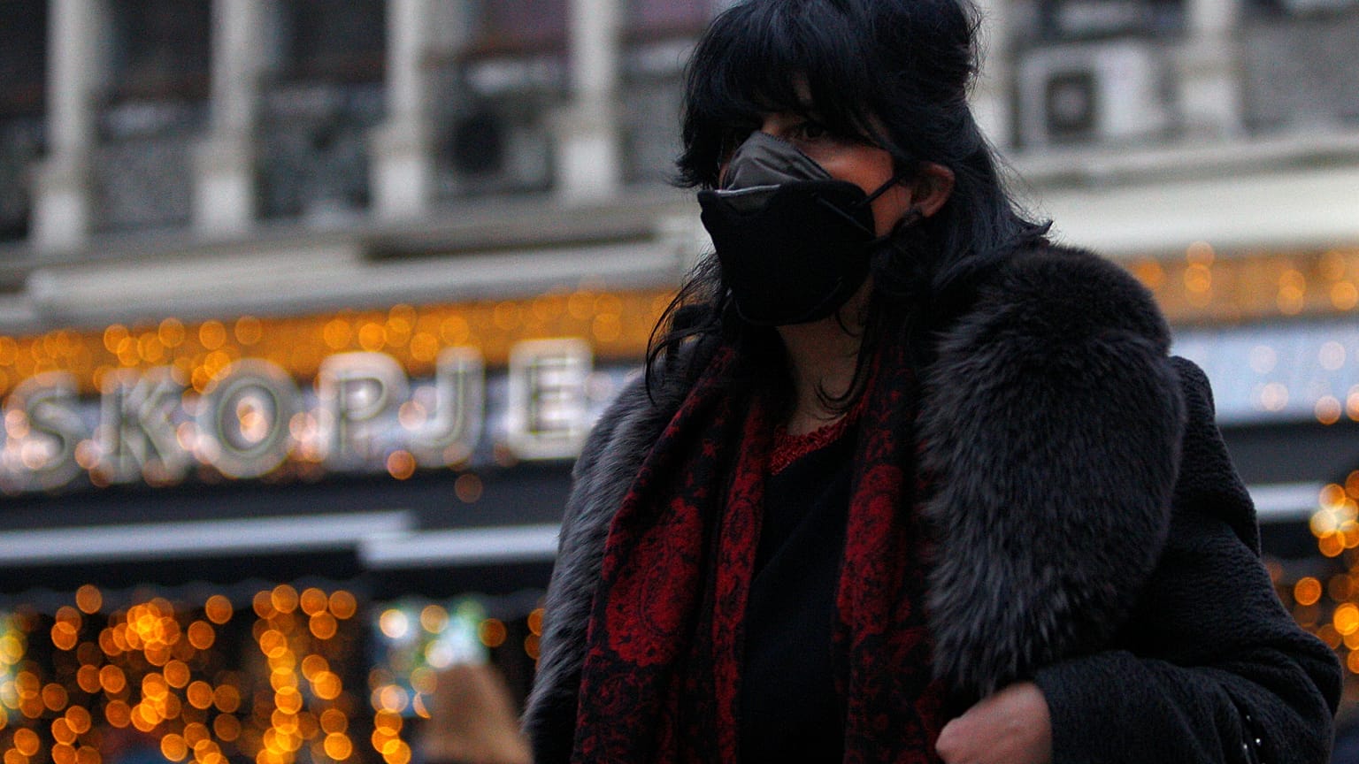 A woman covers her face as air pollution reaches dangerous levels in Skopje