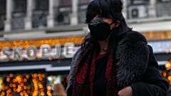 A woman covers her face as air pollution reaches dangerous levels in Skopje