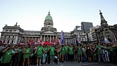 Activists hold hands outside the Argentine National Congress