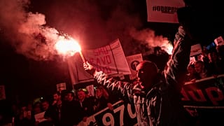 A demonstrator holds a flare during civic protest in Podgorica, Montenegro