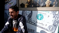 مواطن ليبي يجلس أمام مكتب للصرافة في بنغازي