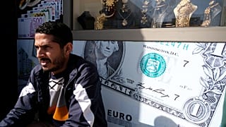 مواطن ليبي يجلس أمام مكتب للصرافة في بنغازي