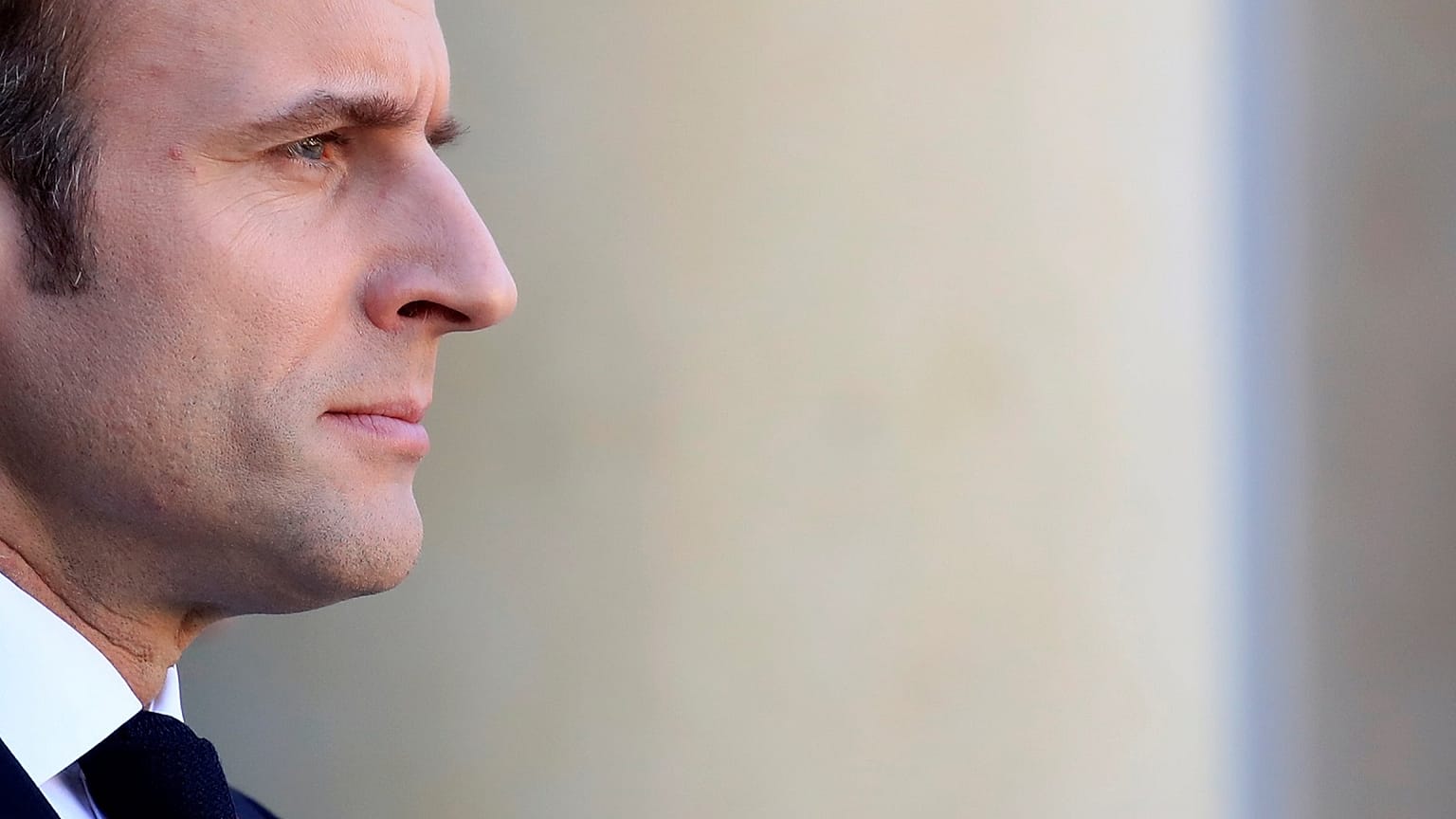 Emmanuel Macron watches as Angela Merkel leaves a meeting in Paris.