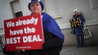 An anti-Brexit and a Pro-Brexit protester hold up signs in London, Britain 