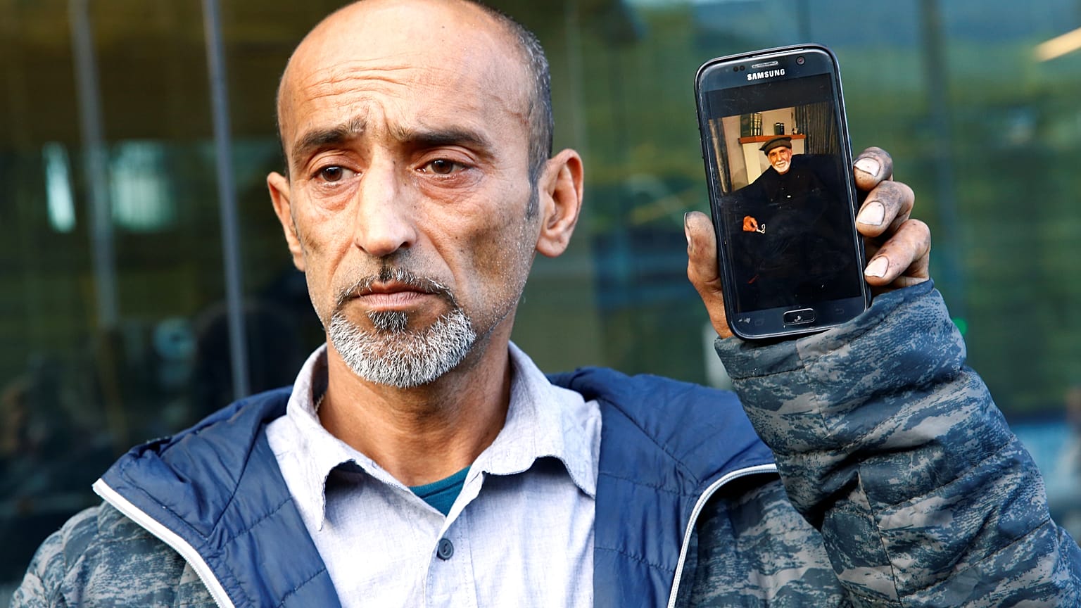 عمر نبي أمام محكمة كرايست تشيرش يحمل صورة والده الذي قضى في حادثة نيوزيلندا