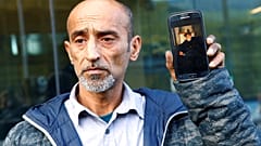 عمر نبي أمام محكمة كرايست تشيرش يحمل صورة والده الذي قضى في حادثة نيوزيلندا