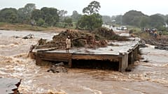 A man looks at a washed away bridge along Umvumvu river in Chimanimani
