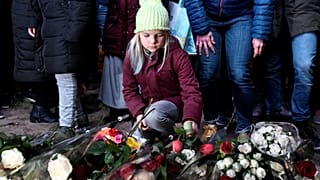 A girl lays flowers during a silent march in Utrecht to honour victim