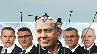 عمال يقومون بتنصيب لوحة دعائية لحزب نيتنياهو خلال الحملة الانتخابية للكنيست