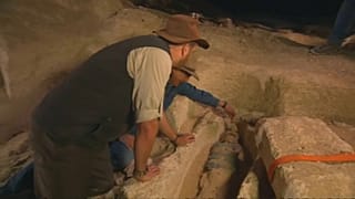 Archeologists observing mummy
