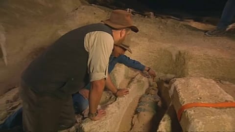 Archeologists observing mummy