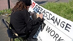 Ein Demonstrant schreibt ein Banner vor dem Belmarsh-Gefängnis