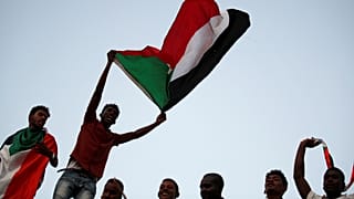 محتجون سودانيون يلوحون بالأعلام ويهتفون أمام وزارة الدفاع في الخرطوم