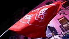 Eine Flagge der PSOE weht vor Pedro Sánchez