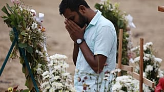 رجل يبدو متأثرا خلال مراسم جنائزية لضحايا هجمات في كنيسة في نجومبو