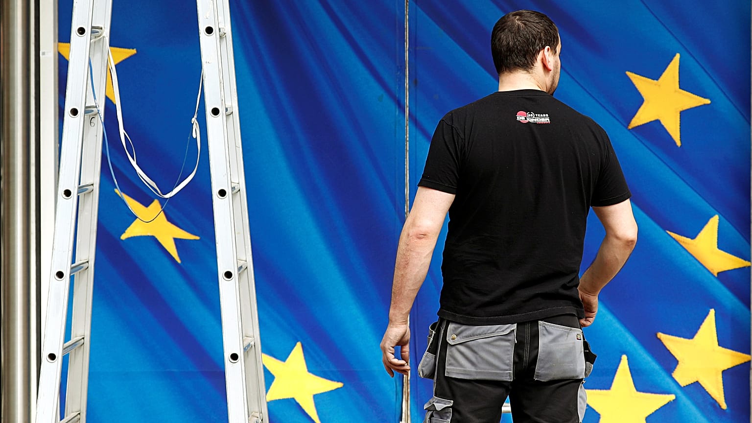 A worker is pictured in front of an entrance to the EU Commission HQ