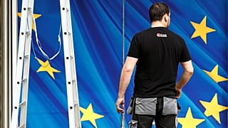 A worker is pictured in front of an entrance to the EU Commission HQ