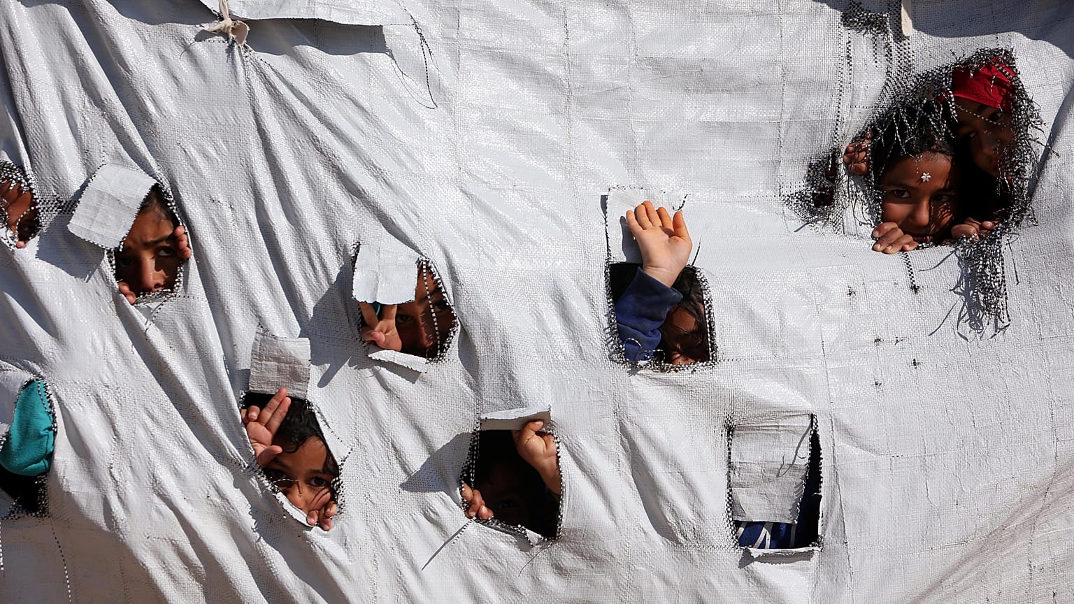 Enfants sortant leurs têtes d'une tente dans le camp d'Al-Hol