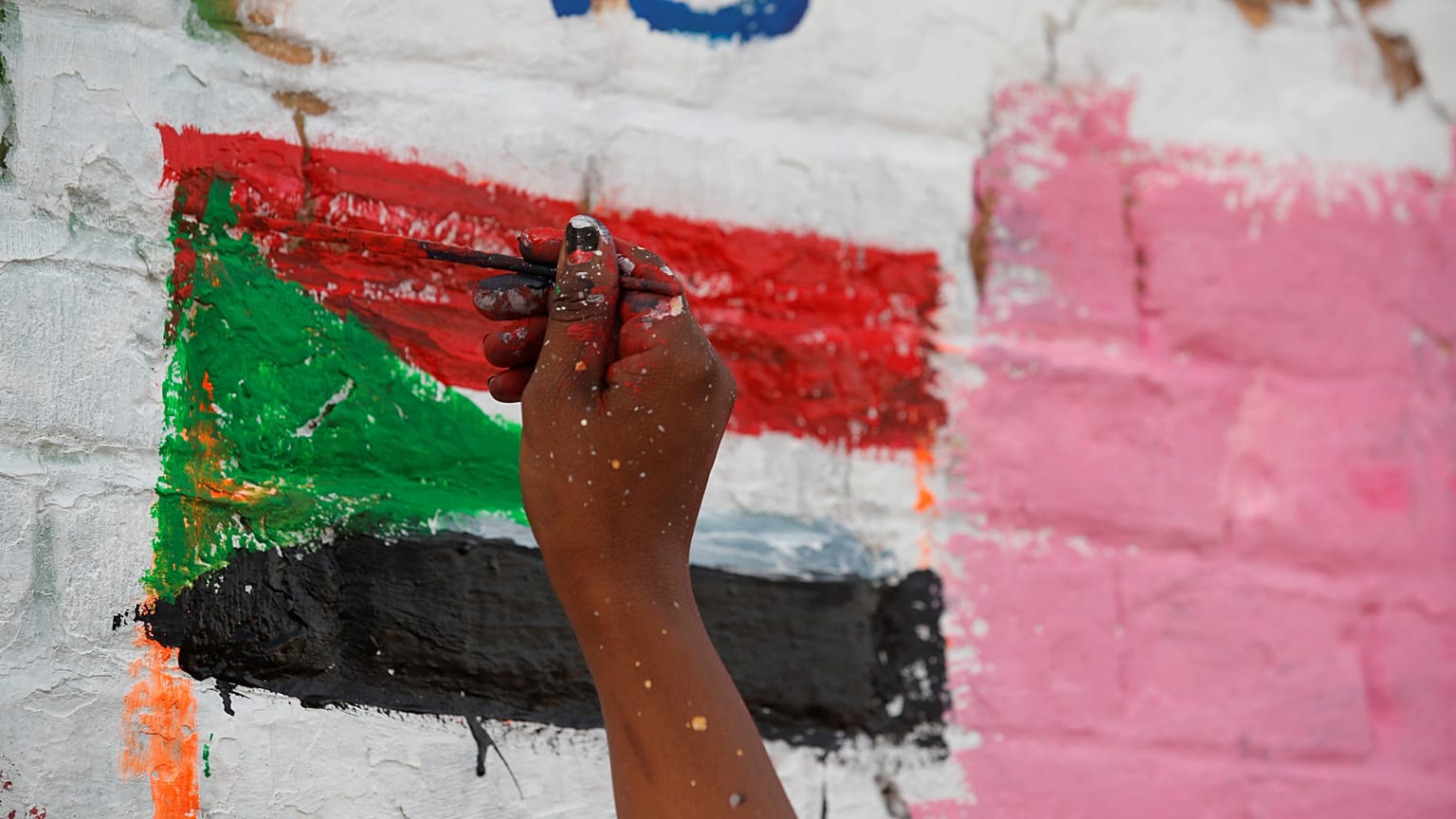 محتج سوداني يرسم على جدار مجاور لمقر وزارة الدفاع في الخرطوم 