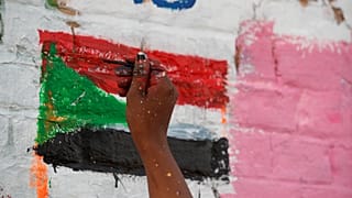 محتج سوداني يرسم على جدار مجاور لمقر وزارة الدفاع في الخرطوم 