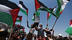 متظاهرون يحملون الأعلام الفلسطينية أثناء الاحتفال بالذكرى 71 للنكبة