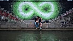 Egy pár ül a Duna partján Bécsben 2017 nyarán