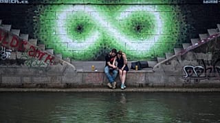 Egy pár ül a Duna partján Bécsben 2017 nyarán