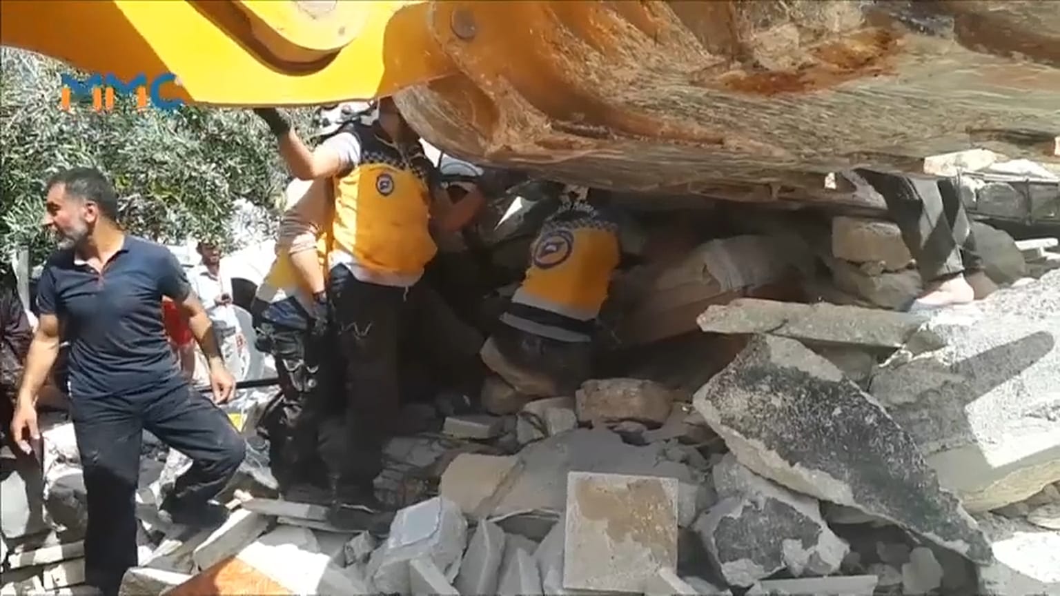 عناصر من القبعات البيضاء يتعاونون مع مدنيين لانتشال الفتى من تحت الأنقاض