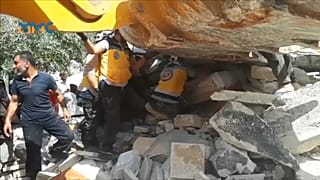عناصر من القبعات البيضاء يتعاونون مع مدنيين لانتشال الفتى من تحت الأنقاض