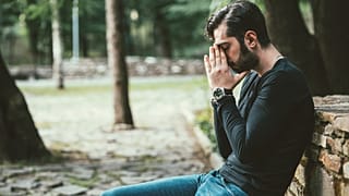 Depressed, anxious man on a park bench