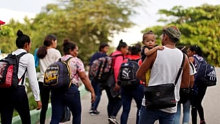 Migrantes caminan después de cruzar el río Suchiate en una balsa desde Tecun Uman, en Guatemala