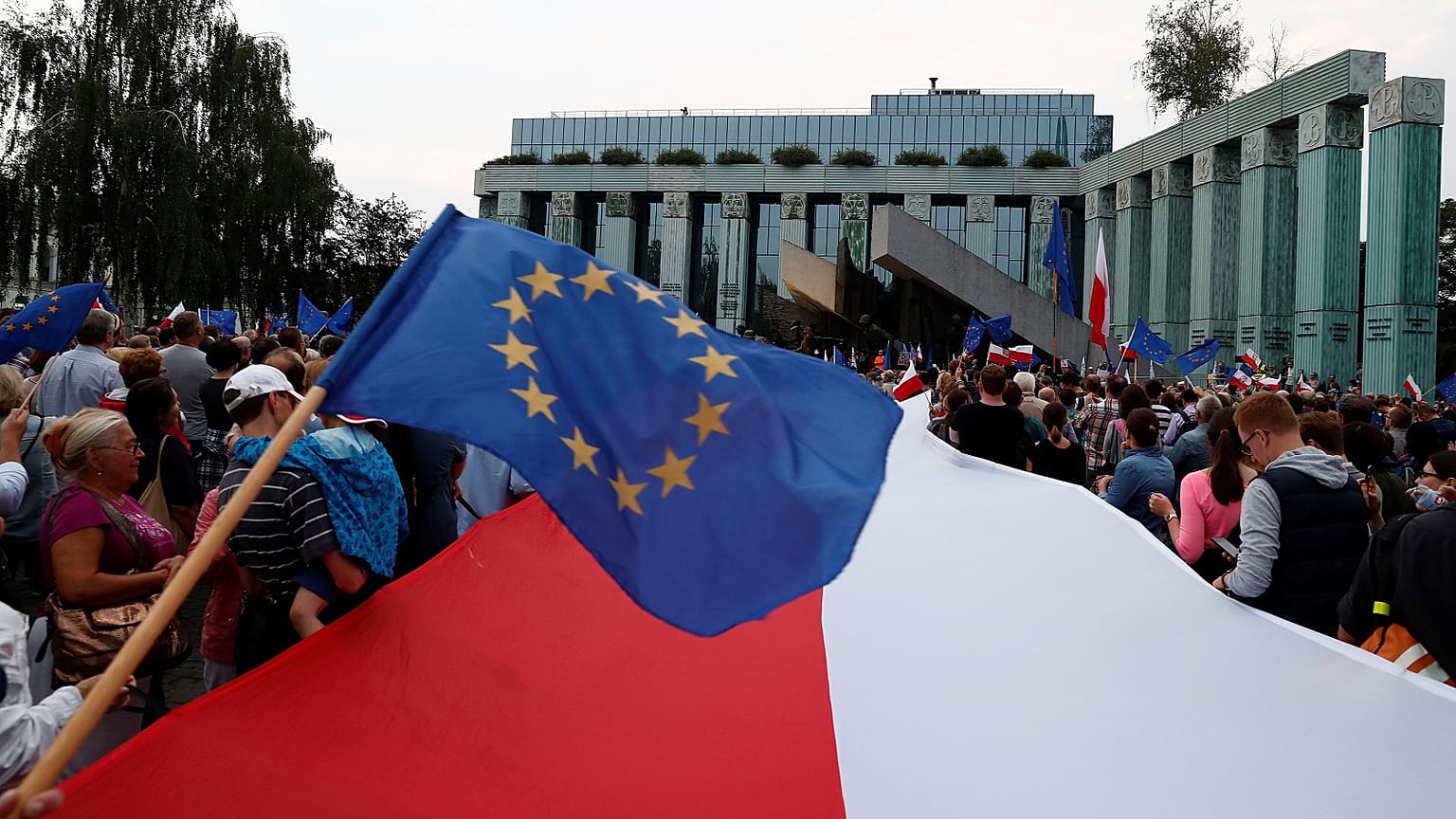 People wave European Union and Polish flags during a protest against supreme court legislation in Warsaw, Poland, July 21, 2017