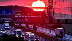  A felkelő napkorong fénye világít be egy autópályát Frankfurt közelében 2019. június 5-én