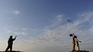 Afghan boys engaging in child play flying kites in Kabul, Afghanistan