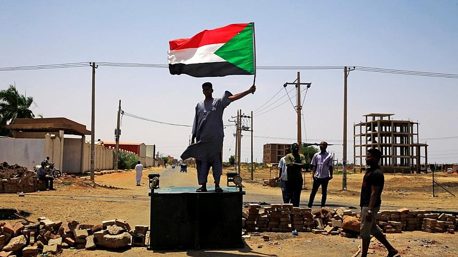 متظاهر يرفع علم السودان