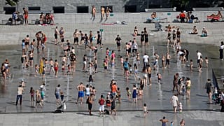 People cool off in the fountains at the Andre Citroen park in Paris as a heatwave hit much of the country, France, June 25, 2019. 